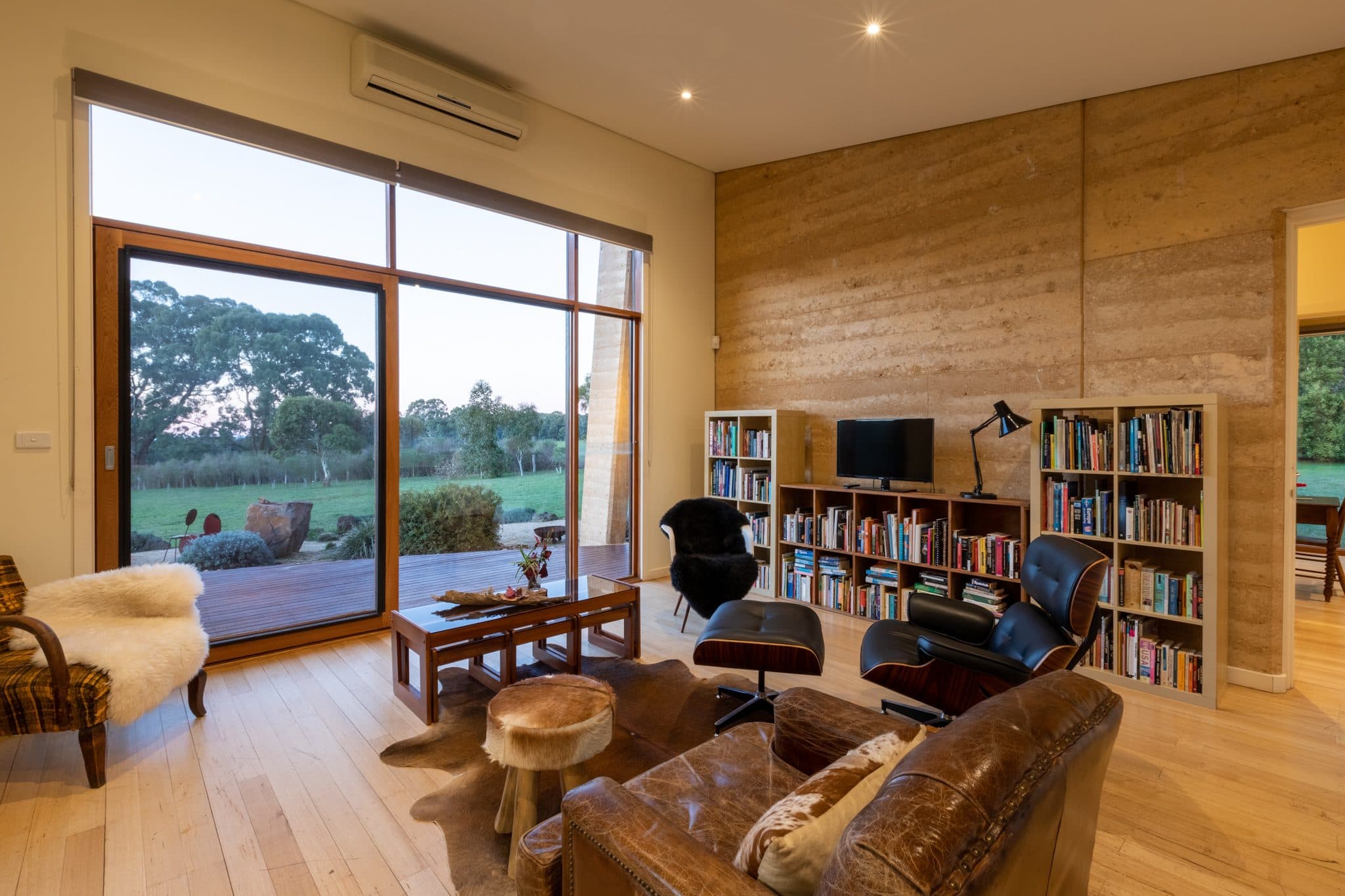 Bedroom with rammed earth walls and bush views
